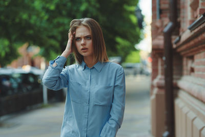 Portrait of young woman standing in city