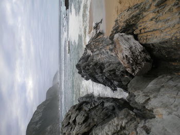 Rocks on beach against sky