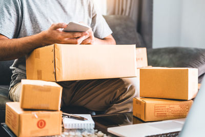 Midsection of man using mobile phone in box