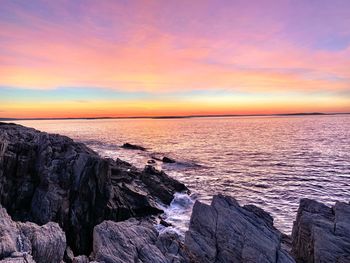 Scenic view of sea against dramatic sky during sunset