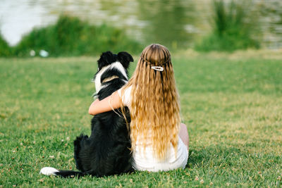 Rear view of woman with dog on field