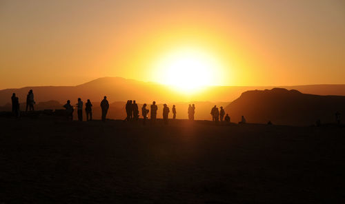 Silhouette people on mountain against clear sky during sunset