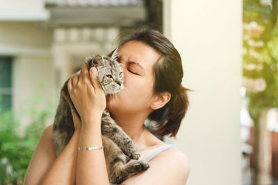 Close-up of woman kissing cat at home