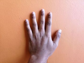 Close-up of woman hand against wall
