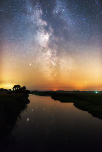 Scenic view of lake against sky at night