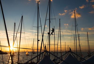 Silhouette sailboats on sea against sky during sunset