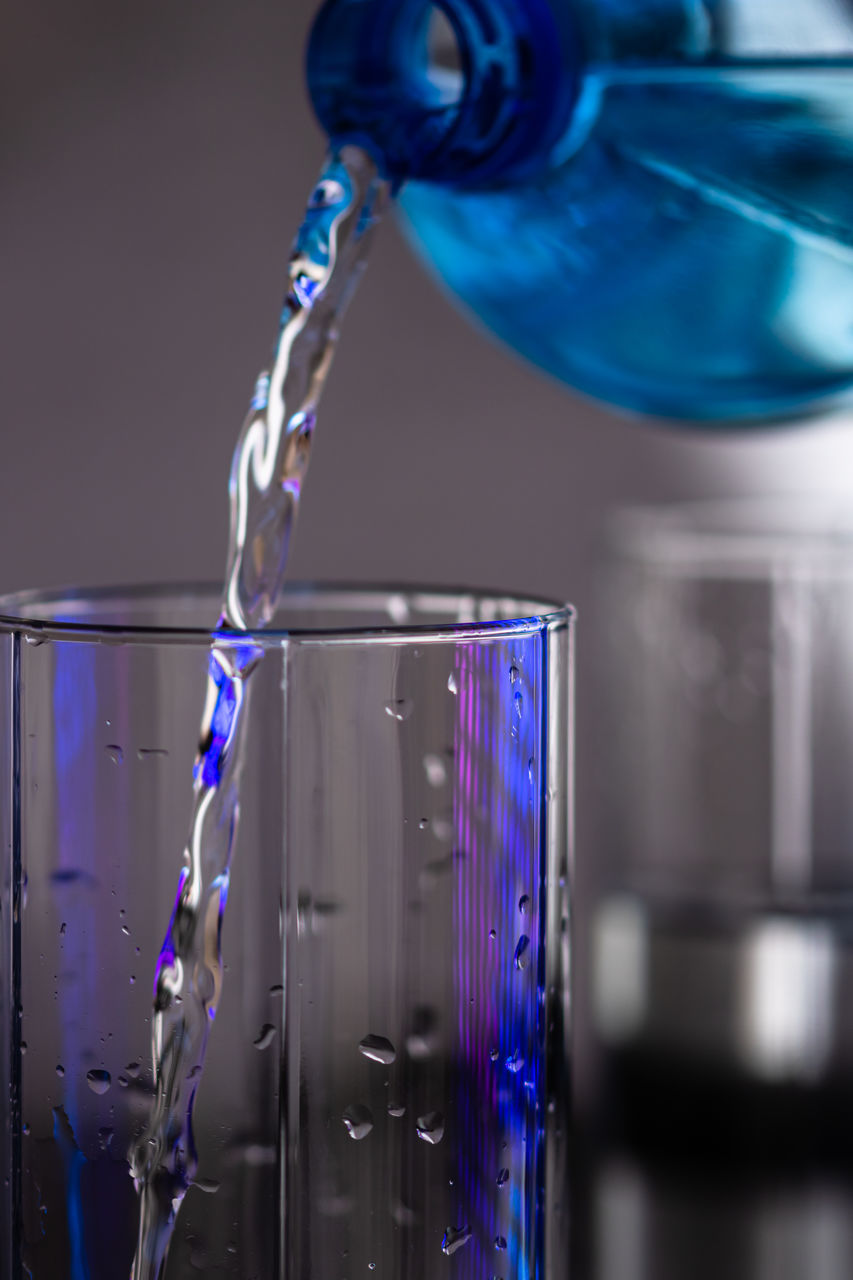 blue, glass, indoors, water, pouring, motion, close-up, household equipment, drink, science, cobalt blue, refreshment, food and drink, drinking glass, drop, no people, chemistry, studio shot, scientific experiment, splashing, research