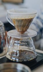 Close-up of black coffee in glass container on table during filtration