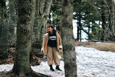 Portrait of young woman standing in forest