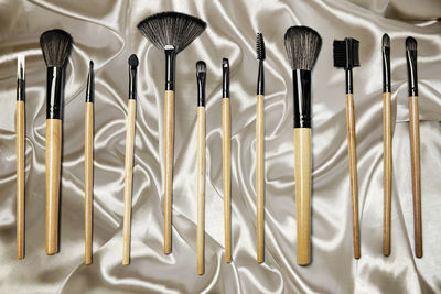 High angle view of make-up brushes on silk