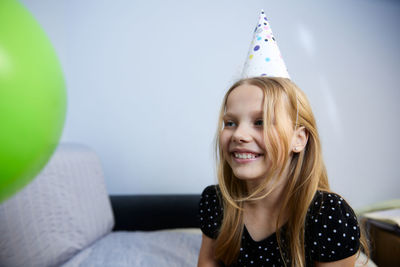 Portrait of young woman sitting on sofa at home