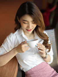 Portrait of young woman drinking coffee