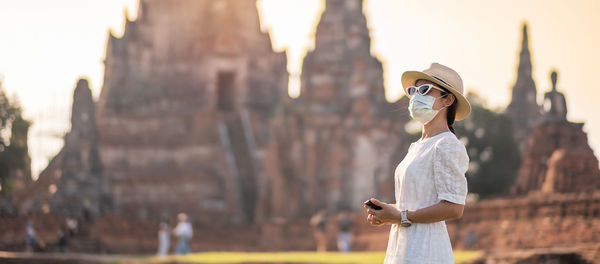 Side view of woman wearing sunglasses standing outdoors