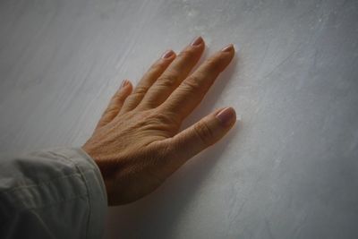 Cropped hand of woman touching white wall