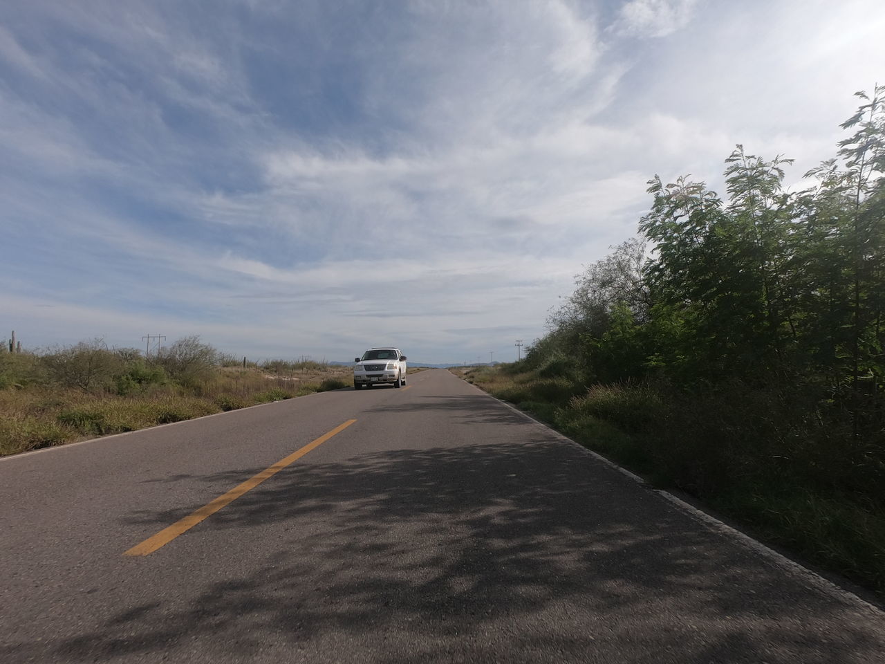 CAR MOVING ON ROAD AGAINST SKY