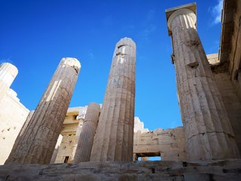 Low angle view of old ruins against clear blue sky in athens, greece