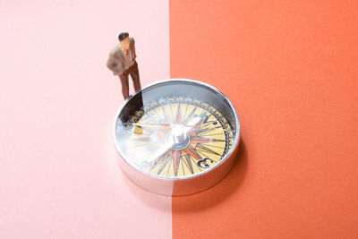 Close-up of navigational compass against yellow background