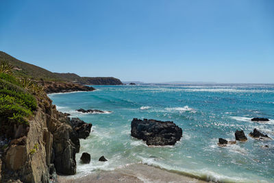 Scenic view of sea against clear blue sky