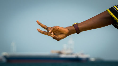 Low angle view of hands against clear sky