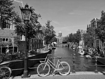 Bicycle parked by street against buildings in city