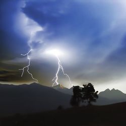 Low angle view of lightning against cloudy sky at dusk