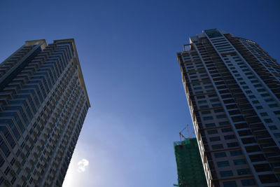 Low angle view of modern buildings against clear blue sky