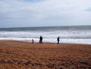 People at beach against sky