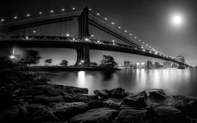 Suspension bridge over river at night