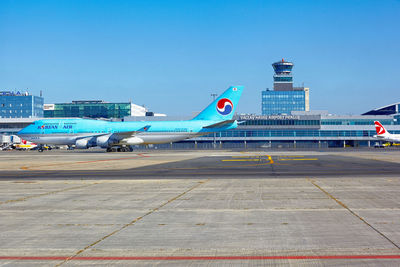 Airplane on airport runway against clear blue sky