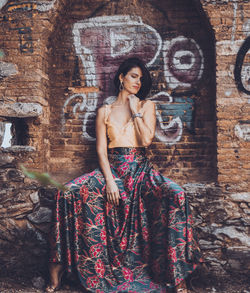 Portrait of a young woman against wall