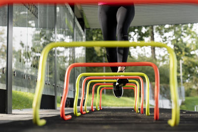 Athlete running over small hurdle by training ground