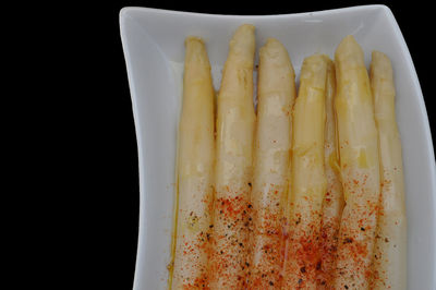 Close-up of bread in plate against black background