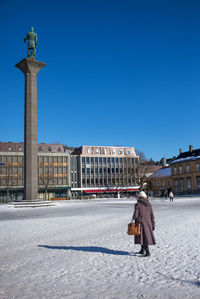 Man on snow against clear blue sky