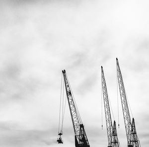 Low angle view of cranes against sky