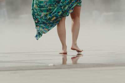 Low section of woman standing on hardwood floor