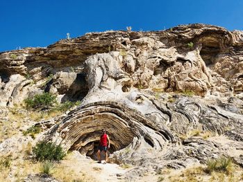 Man on rock standing by rocky mountains