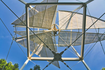 Low angle view of metallic structure against blue sky