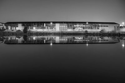 Illuminated buildings with reflection on lake at night