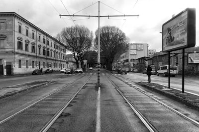 View of railroad tracks by road in city