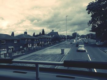 Cars on road against cloudy sky