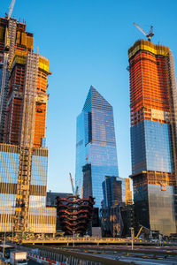 Low angle view of skyscrapers against clear blue sky
