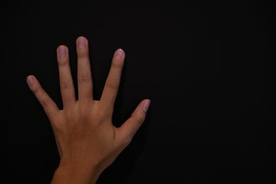 Close-up of hand against black background