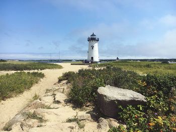 Lighthouse by sea against sky