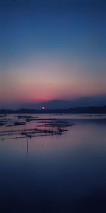 Scenic view of lake against clear sky at sunset