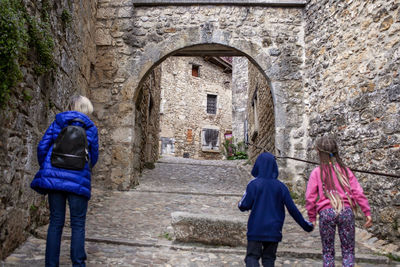 Rear view of man standing against historic building