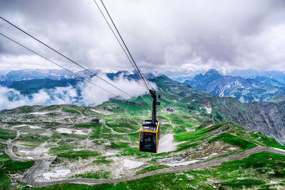 Overhead cable car over snowcapped mountains against sky