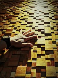 Low section of person relaxing on tiled floor