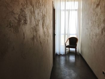 Chair by window in corridor