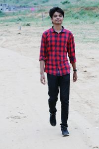 Portrait of young man standing on beach