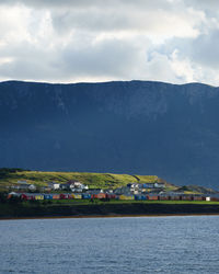 Scenic view of sea by buildings against sky